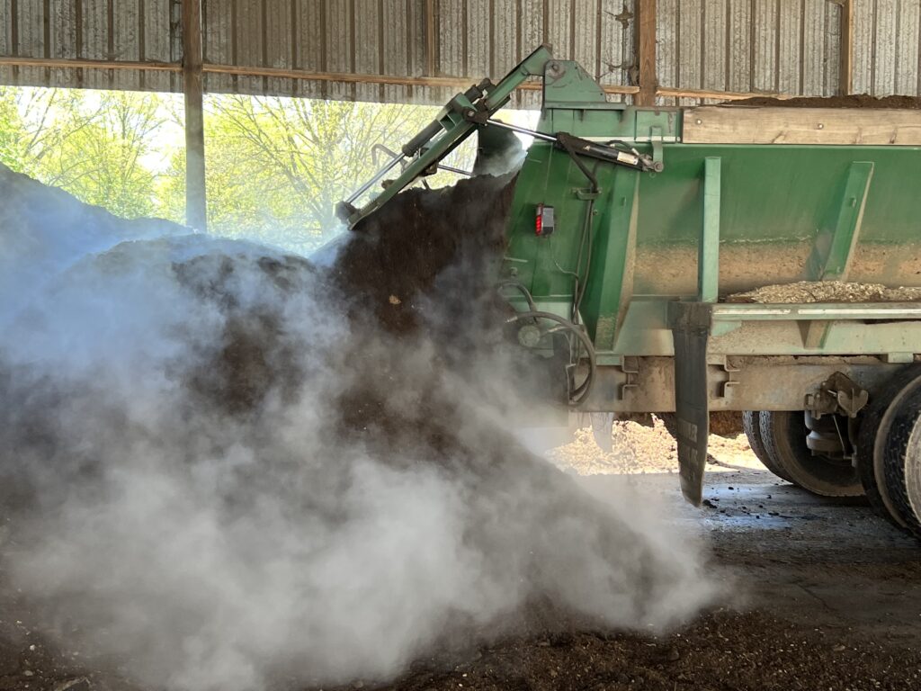 truck dumping compost into pile
